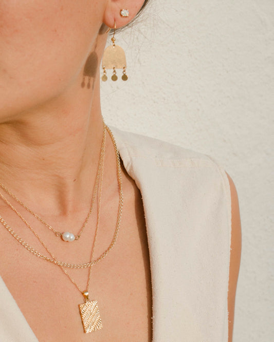 Model wears layer gold chain necklaces